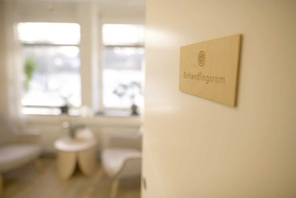 Dør inn til rolig og innbydende behandlingsrom hos psykolog eller psykiater – diskret og trygg inngang for samtaleterapi